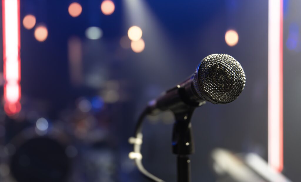 Close up of a microphone on a concert stage with beautiful lighting.